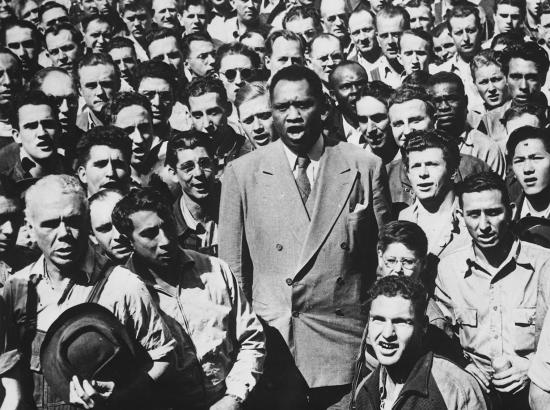 Paul Robeson sings among a crowd of workers