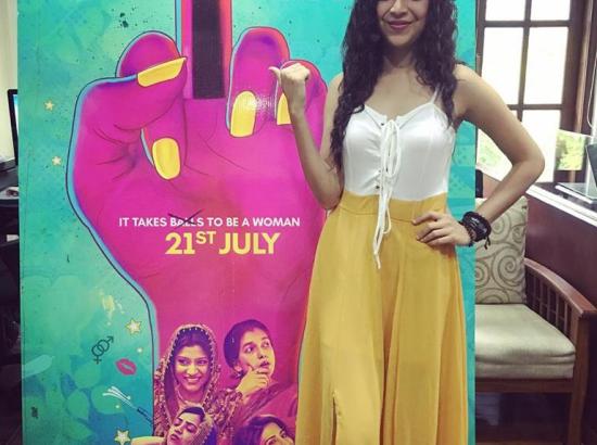 woman stands next to large marketing poster for the film 'Lipstick Under My Burkha' (Source: the author)