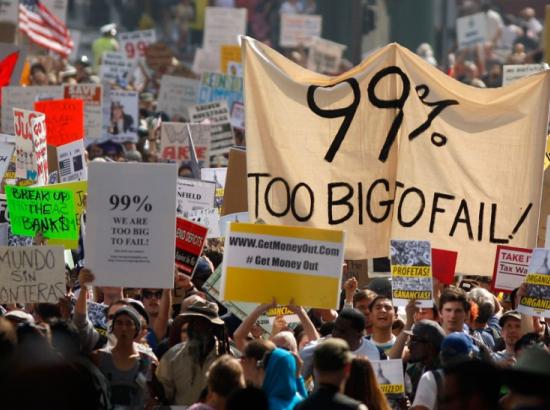protest banner reads '99% Too Big To Fail'