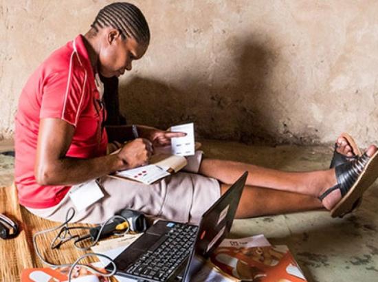 researcher with laptop logging fieldwork data in South Africa