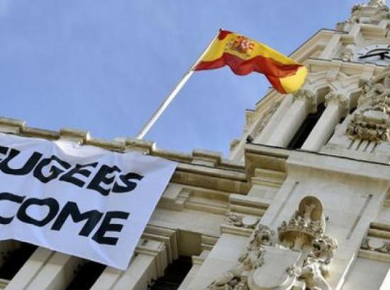 banner reading 'Refugees Welcome' hangs from the front of the city hall building in Madrid