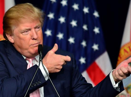Donald Trump holding up his arms at public address in gesture of holding a rifle