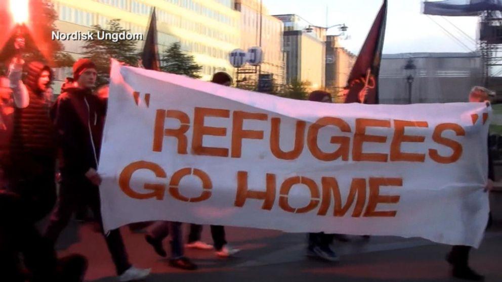 protestors carry 'Refugees Go Home' banner in central Stockholm, 2015