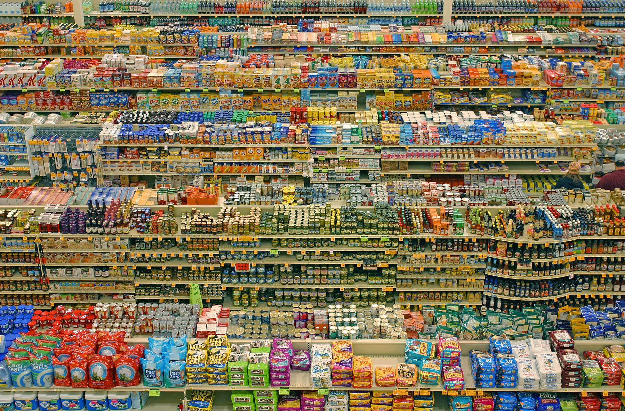 view from above across the aisles of fully stocked shelves in a supermarket 