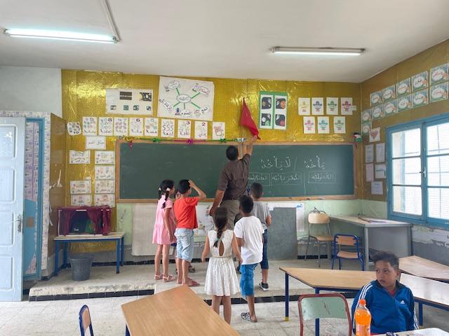 Teacher and students in a popular/disadvantaged neighborhood in the Tunisian capital, Tunis 