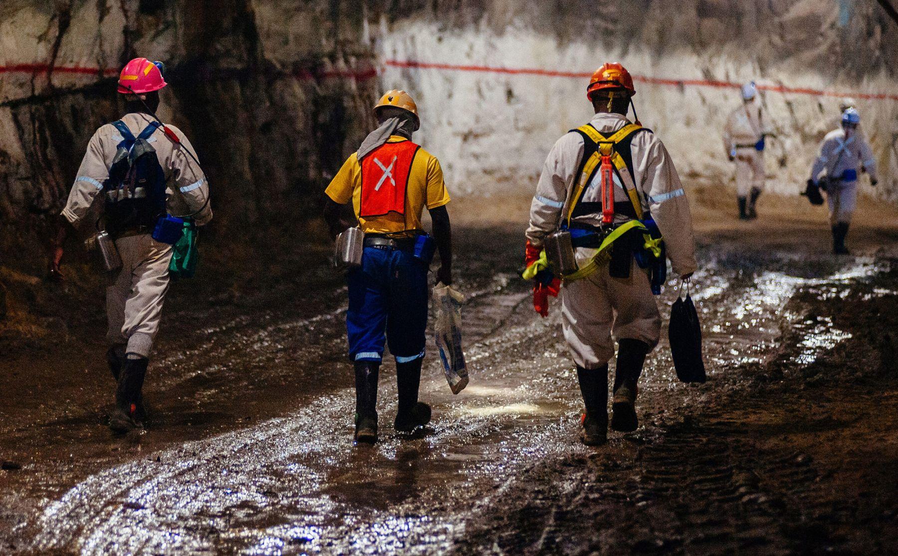 Miners walk through an underground tunnel at a gold mine in South Africa.