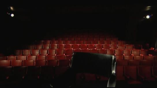 Empty cinema in low light viewed from the stage -- Screen grab from Jogo de Cena (Playing) by Brazilian director Eduardo Coutinho, 2007.