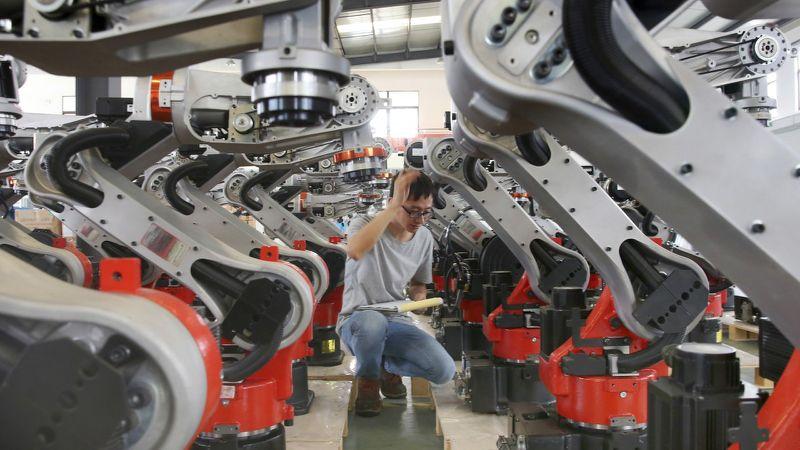 a sole technician surrounded by state-of-the-art robots at plant in China.