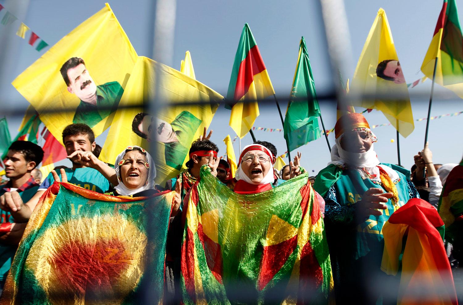 protesters holding Kurdish and PKK flags, banners