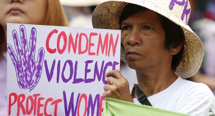 Filipino protestor hold a placard reading "CONDEMN VIOLENCE - PROTECT WOMEN"