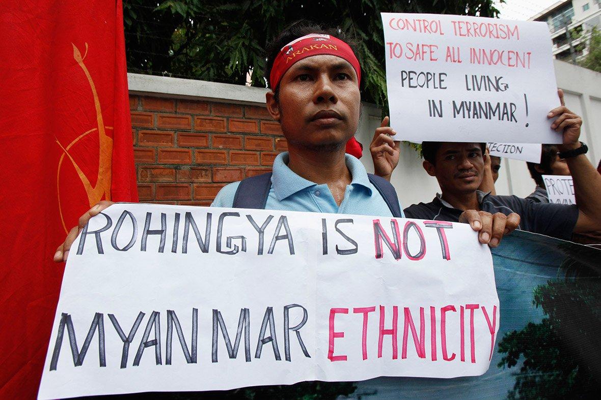 Burmese nationalist protester holding banner denying Rohingya ethnicity