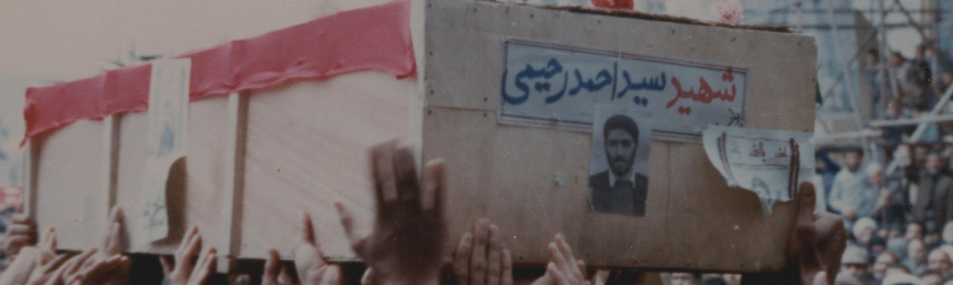 mourners holds aloft the casket of an Iranian martyr