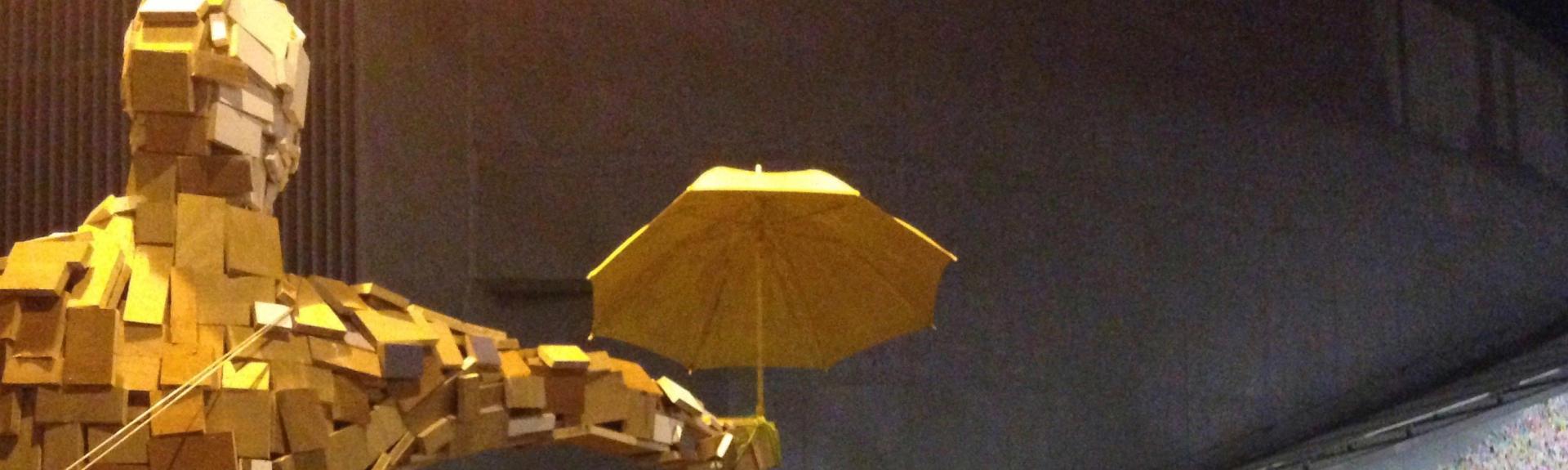 photo of “Umbrella Man” by Hong Kong artist Milk, with Post-It note covered “Lennon Wall.”