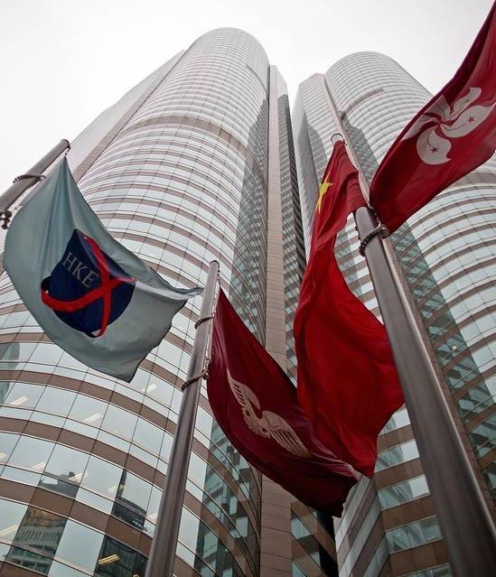 flag of the Hong Kong Exchanges and Clearing, left, flies outside the Exchange buildings