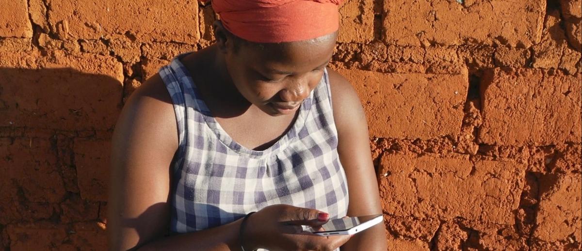 African woman texting on smartphone