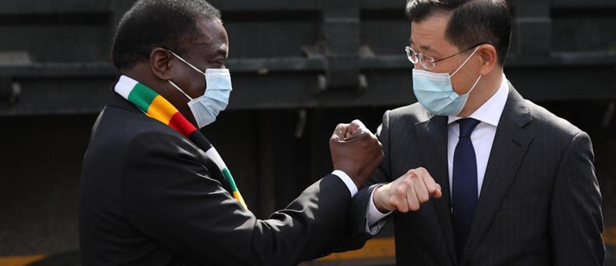 Zimbabwean President Emmerson Mnangagwa (L) and Chinese ambassador to Zimbabwe Guo Shaochun elbow bump