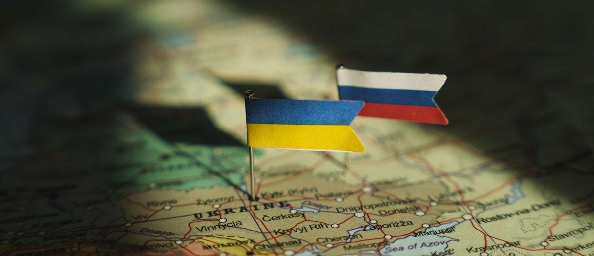 pinned flags of Ukraine and Russia on a map