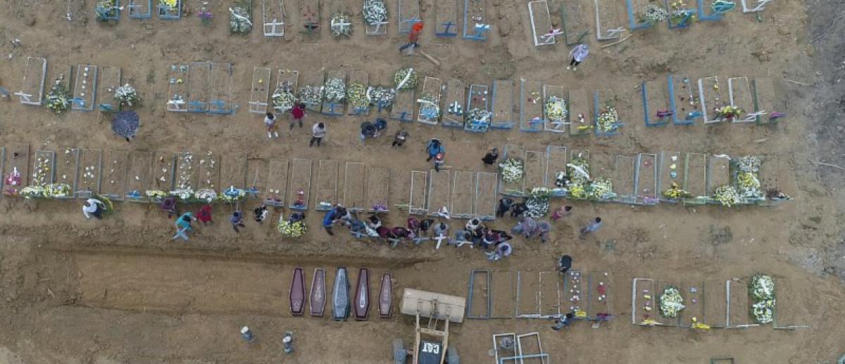 A backhoe buries coffins in a common pit at the Nossa Senhora Aparecida cemetery in Manaus, Brazil