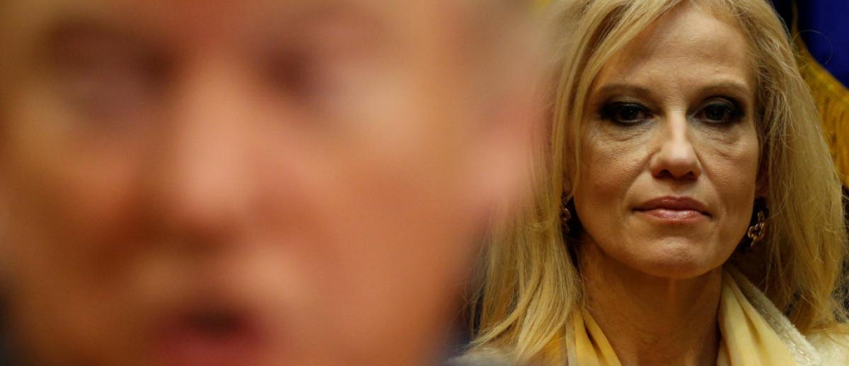 Kellyanne Conway stands in focus behind camera blurred Donald Trump - photo