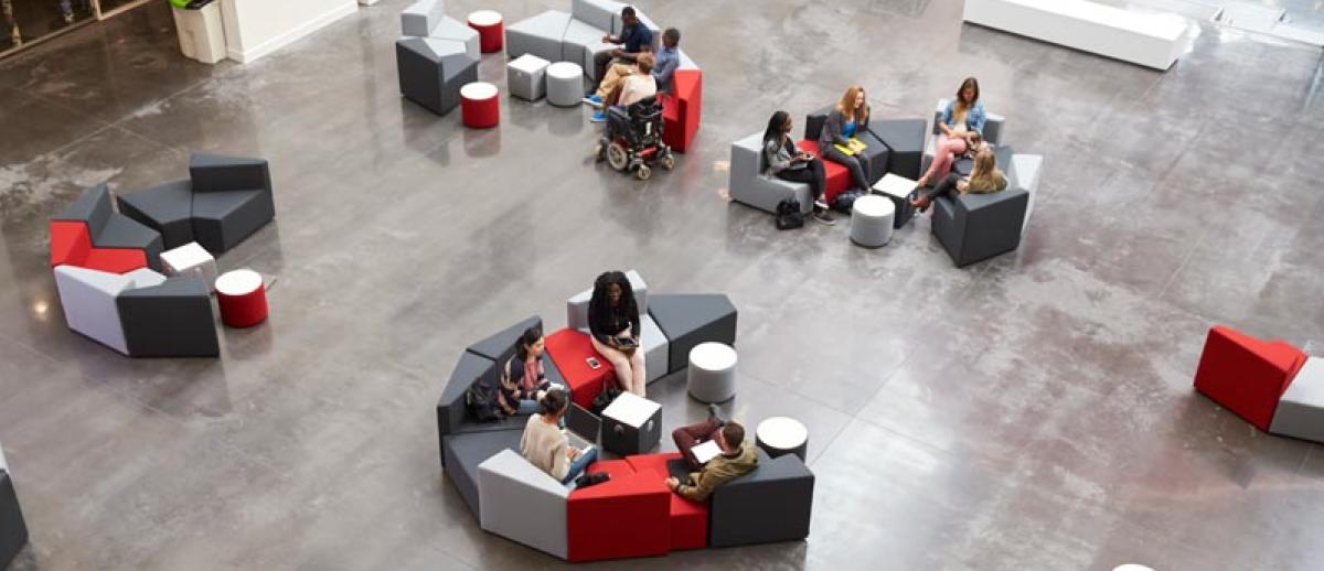 students seated in well-furnished clusters in a university study space