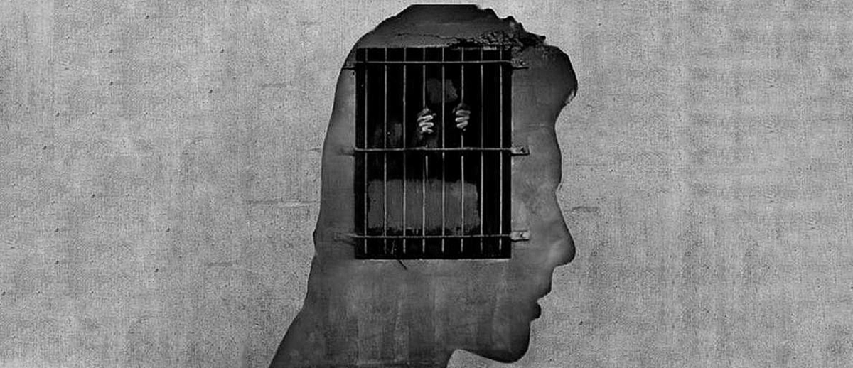 mural of head in profile over barred window clutched by human hands