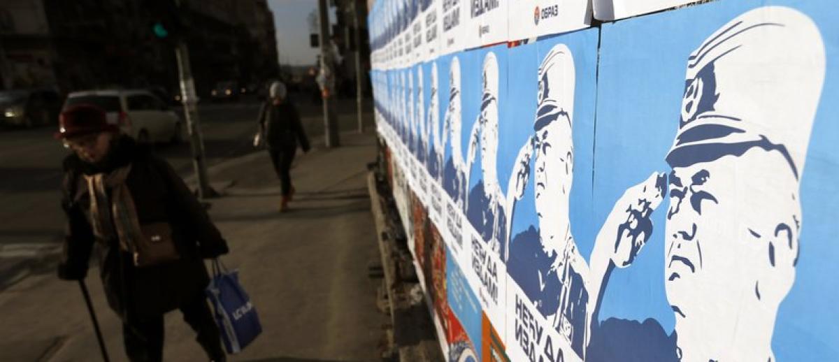 pedestrians pass by posters showing former Bosnian Serb wartime general Ratko Mladic, reading: ″I won’t betray!″, in Belgrade, Serbia, Dec. 6, 2017.
