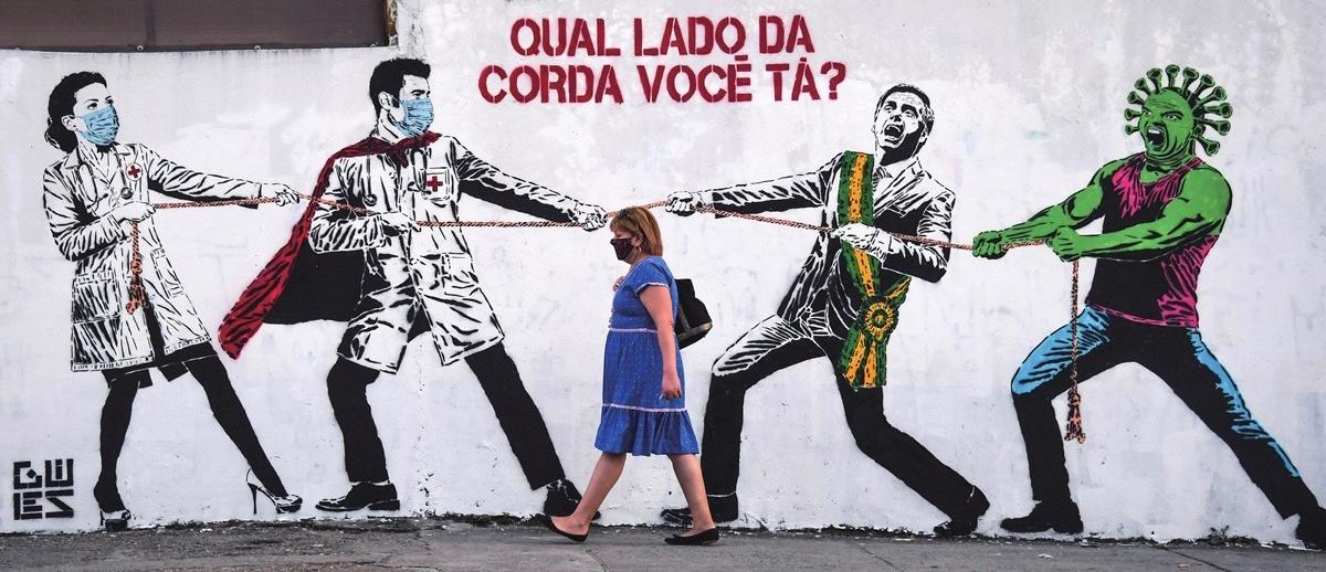 mural in Sao Paolo, Brazil depicts a tug of war between masked medical workers on one side, and on the other Brazilian President Jair Bolsonaro with a personified COVID-19 virus
