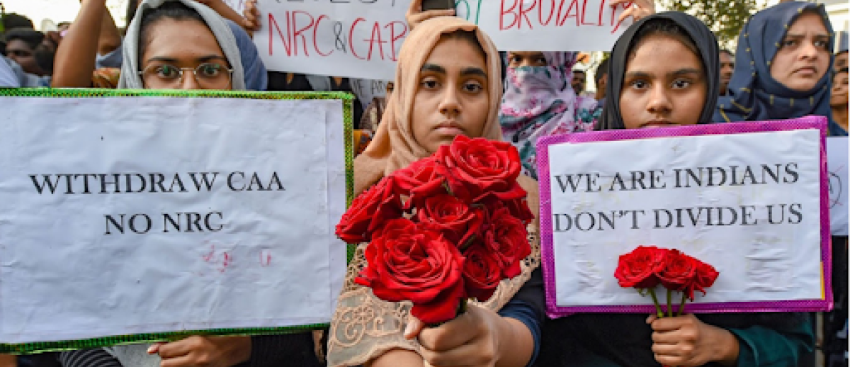Protestors hold placards and roses during a demonstration against the Citizenship Amendment Act (CAA), in Chennai, India