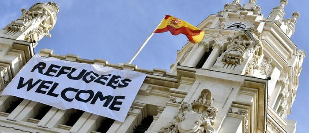banner reading 'Refugees Welcome' hangs from the front of the city hall building in Madrid