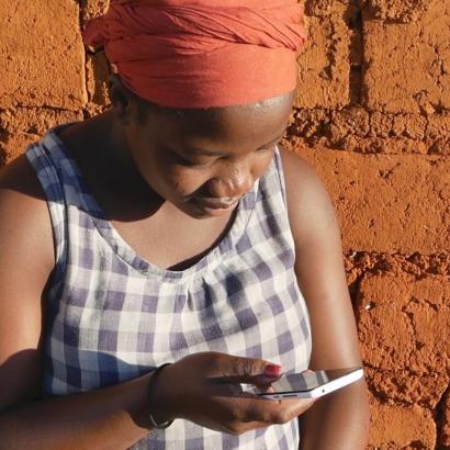 African woman texting on smartphone