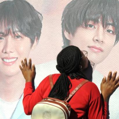 fan kissing the poster-enlarged face of a BTS member