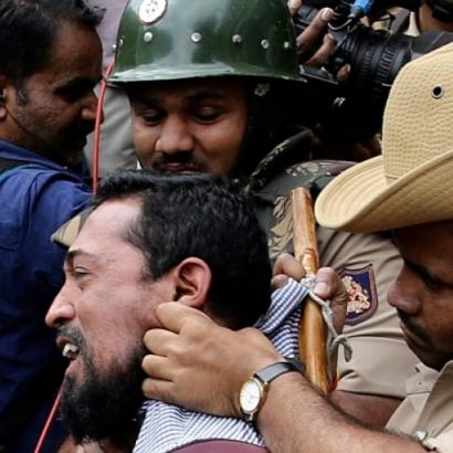 Indian policemen detain people during a protest against the citizenship law in Bangalore