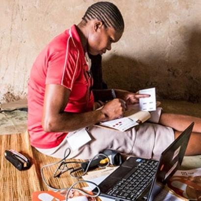 researcher with laptop logging fieldwork data in South Africa