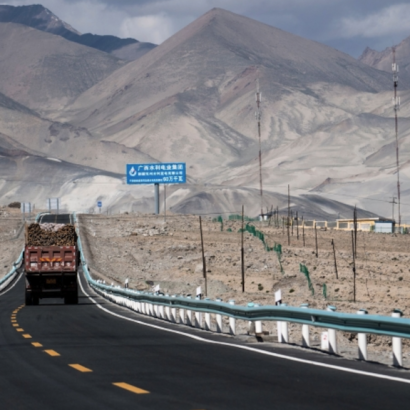 a cargo truck drives along a new highway in mountainous Central Asia