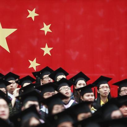 Chinese students attend graduation ceremonies with Chinese flag in background