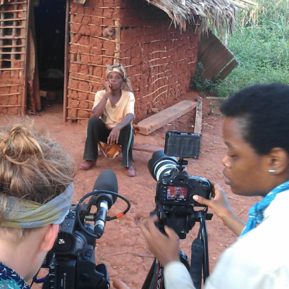 fixer helps a Western photojournalist set up a shot in a village in Africa