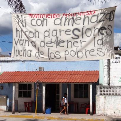 banner in spanish that says "neither with threats nor with aggressions are they going to stop the fight of the poor"