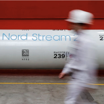 worker passes by a section of pipeline labeled Nord Stream 2